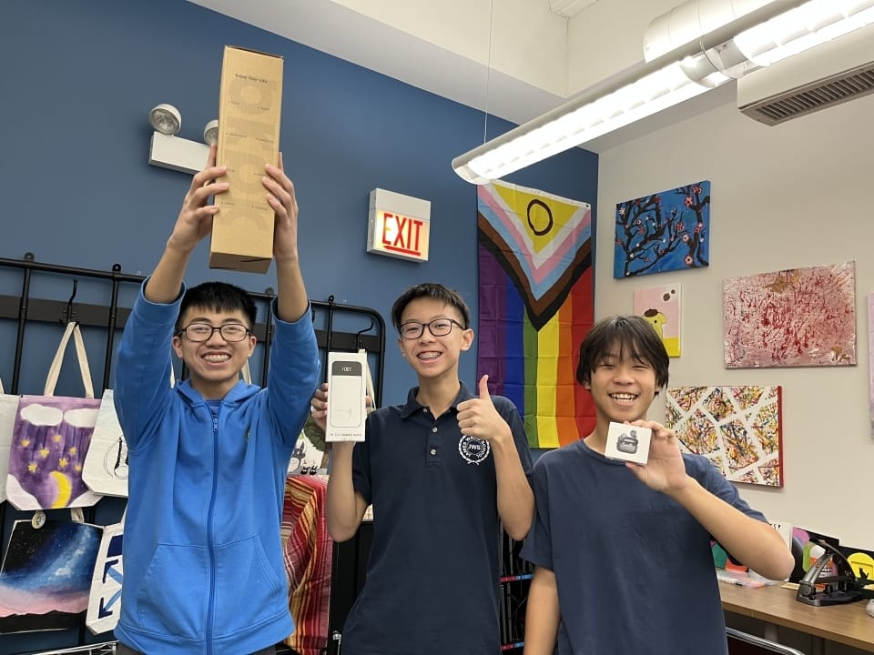 three students hold up gifts